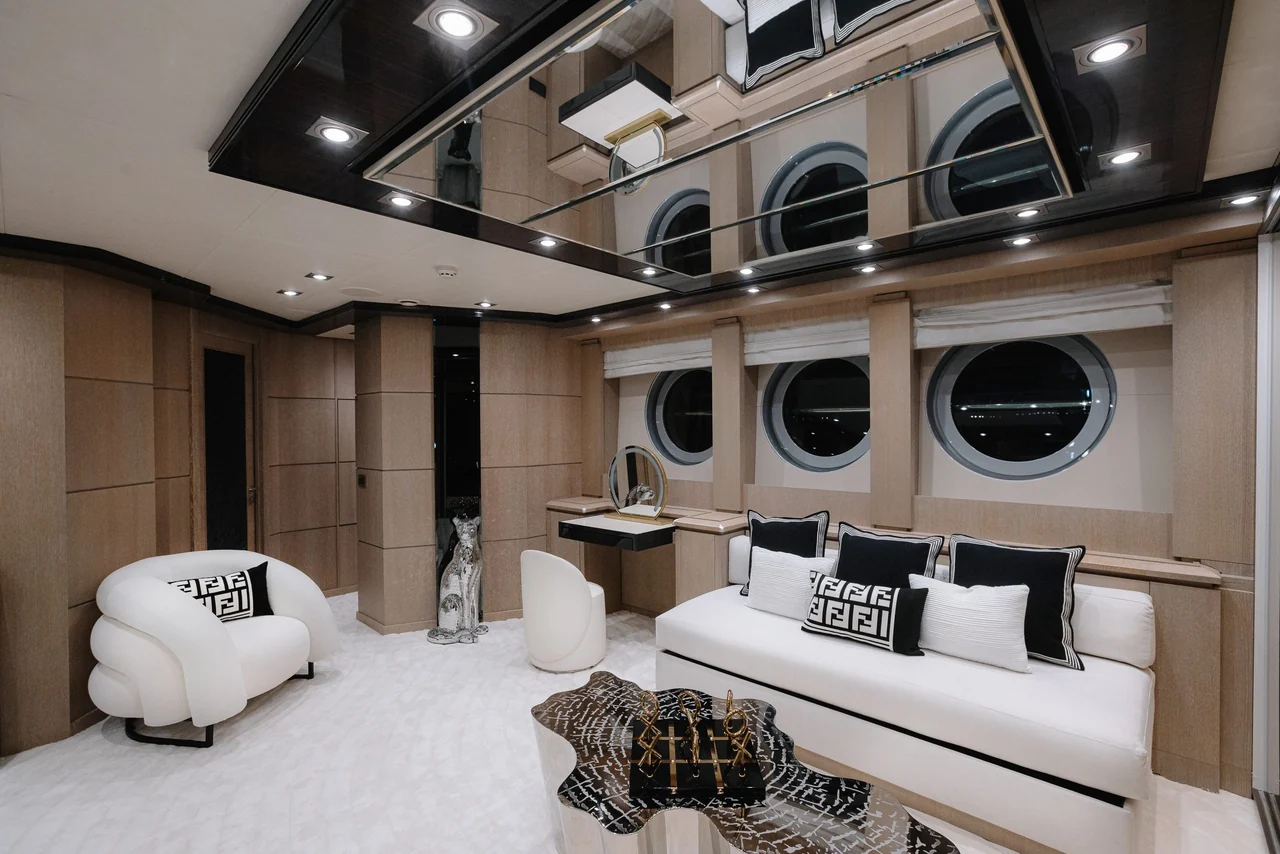 An indoor conversation lounge with portholes aboard Royalty 136