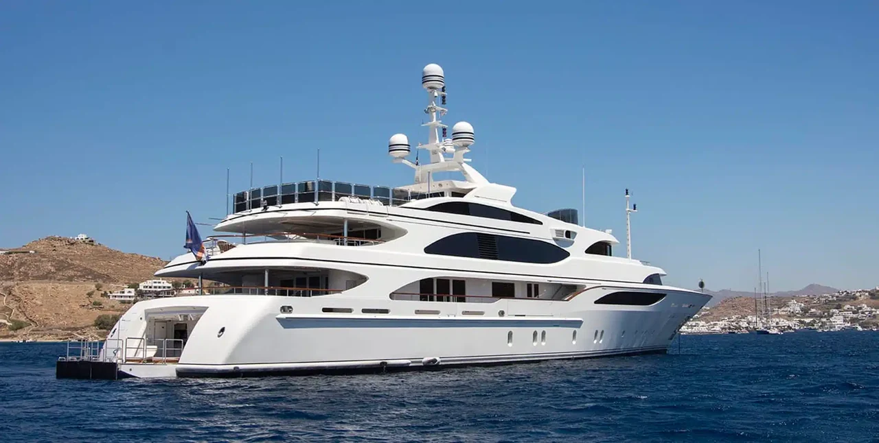 Benetti 60M at anchor beside a rocky coastline