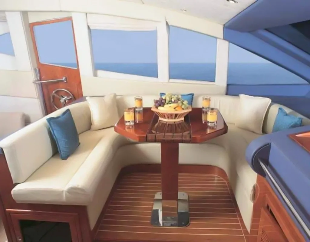 Sheltered curved seating and table aboard Elite Majesty 88