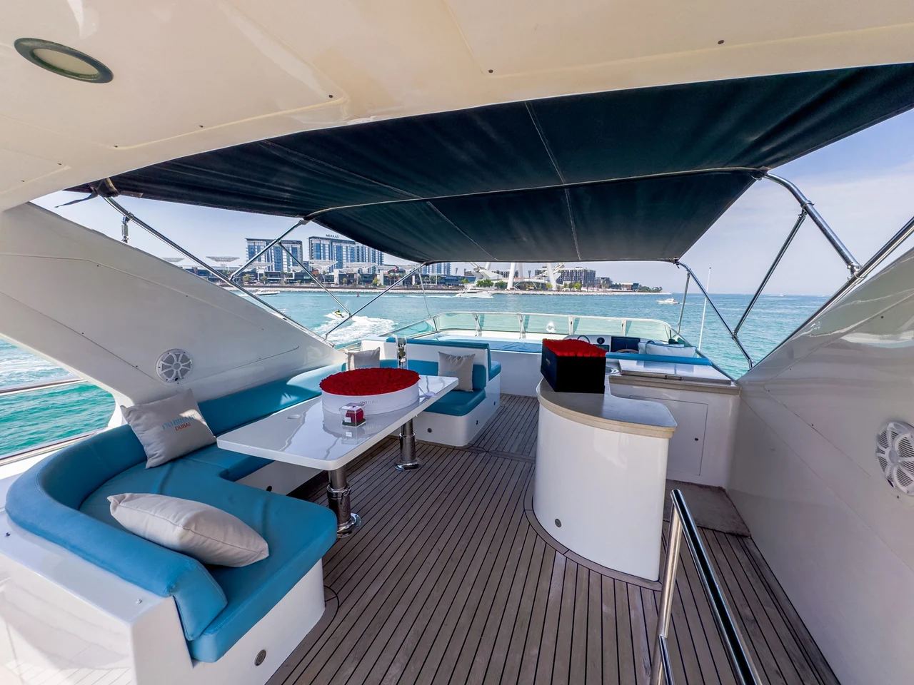 Upper deck dining beneath a dark canopy on Cabo 77
