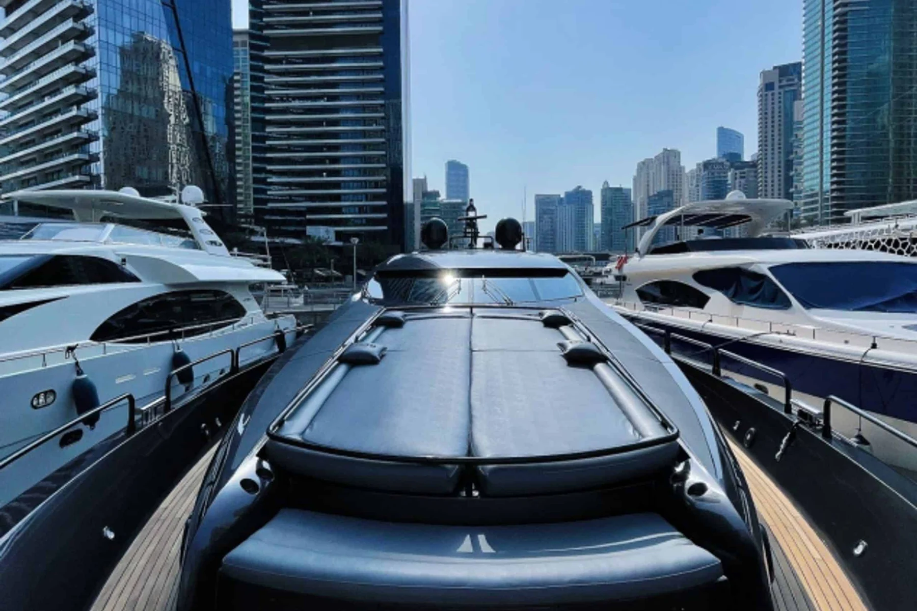 Black Predator 95 Sunseeker yacht foredeck sun lounge with Dubai skyline