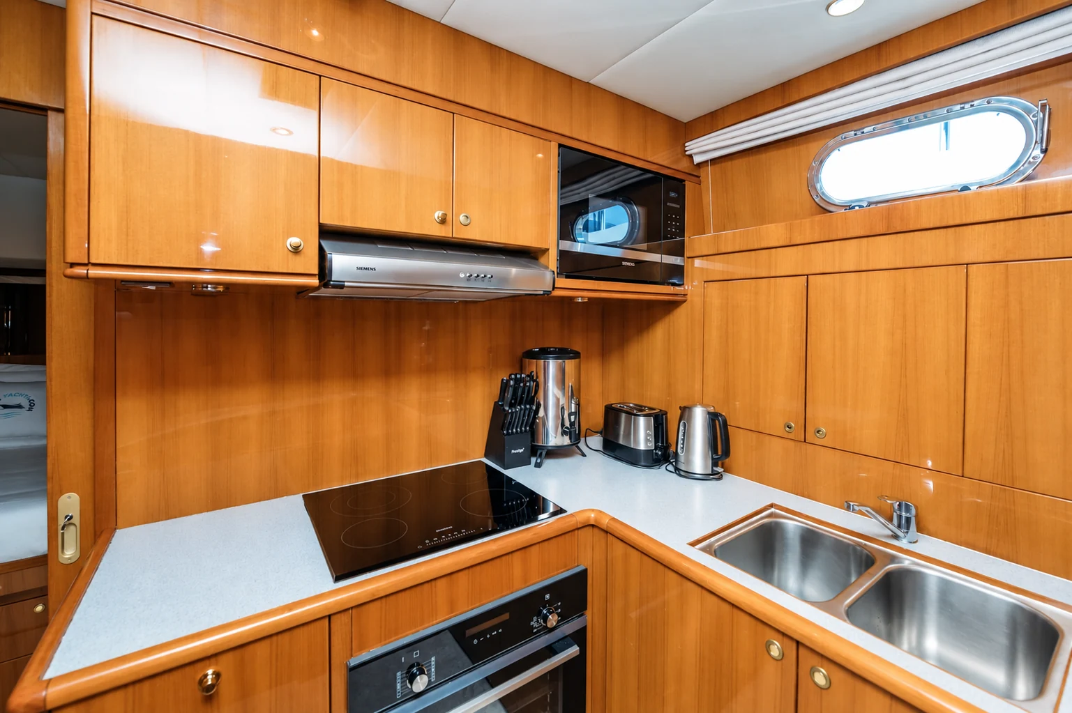 Fully equipped galley kitchen on Eclipse yacht with wooden cabinetry and modern appliances